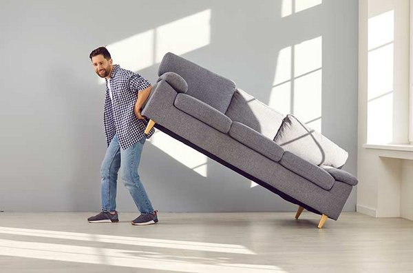 Mann hebt Sofa